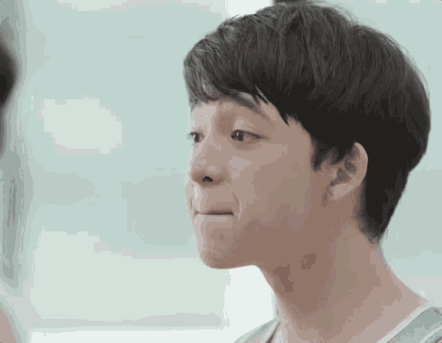 a close up of a young boy 's face making a funny face