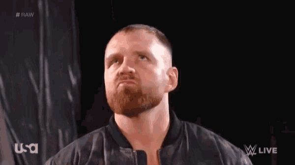 a man with a beard is wearing a leather jacket and making a face .