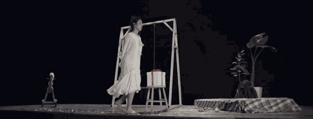 a woman in a white shirt is holding a box in her hands