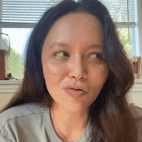 a woman with long hair is making a funny face