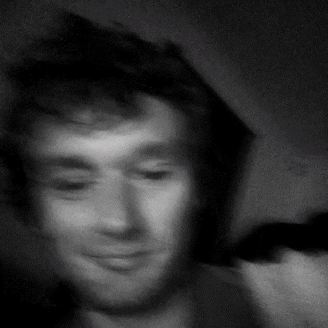 a black and white photo of a man 's face with his eyes closed .