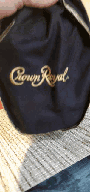 a person is holding a black crown royal bag