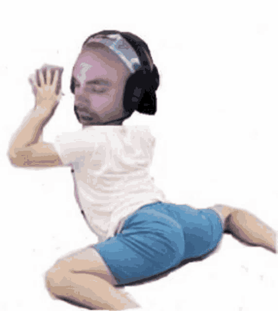 a man wearing headphones and a purple face mask is kneeling down .