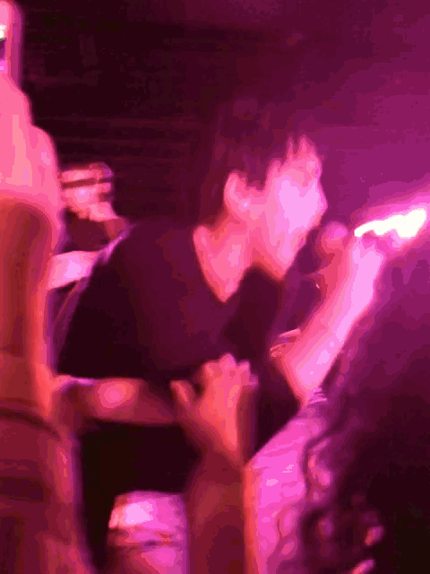 a man singing into a microphone in a crowded room