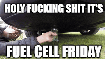 a man is laying under a car with a glass in his hand .