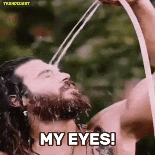 a man with a beard is drinking water from a hose and saying " my eyes "