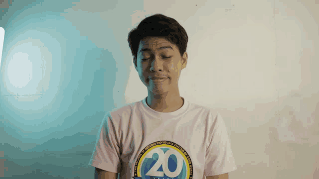 a young man wearing a pink shirt with the number 20 on the front