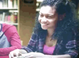 a woman with curly hair is smiling at the camera