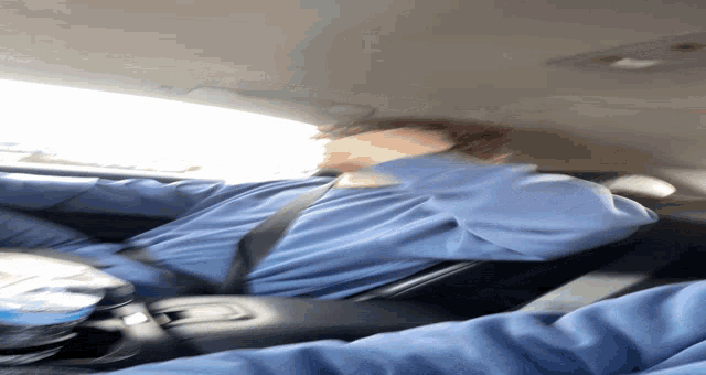 a blurry picture of a person sitting in a car with a bottle of water
