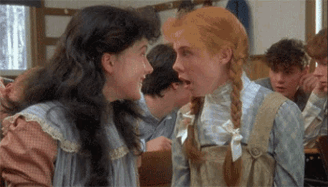 two girls are talking to each other in a room