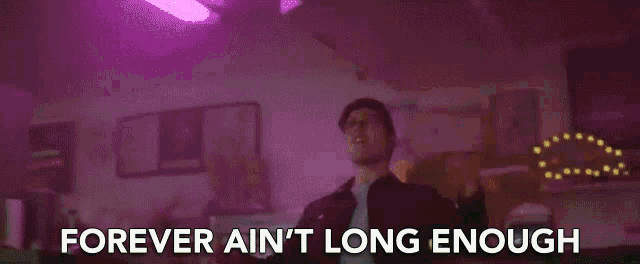a man is dancing in a room with the words forever ain 't long enough above him .