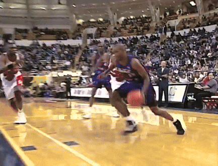 a basketball game is being played in a stadium with a few people watching