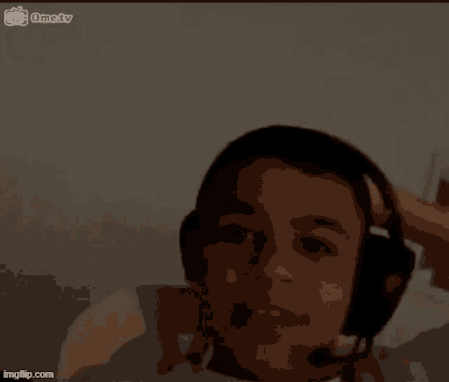 a young boy wearing headphones and a headset is sitting in a chair .