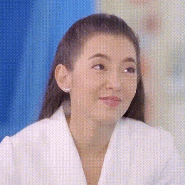 a close up of a woman 's face with a white robe on .