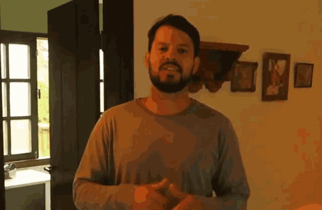 a man with a beard wearing a grey shirt