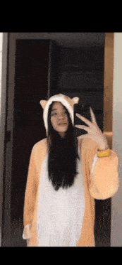 a woman is taking a selfie in front of a mirror wearing a cat costume .