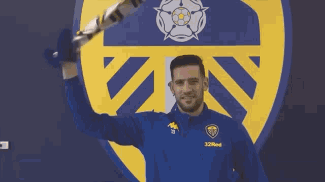 a man wearing a blue and yellow 32red sweatshirt
