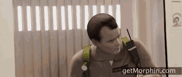a man in a ghostbusters uniform talking on a cell phone