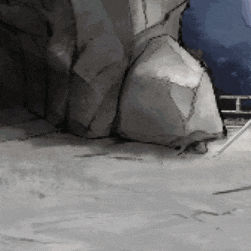 a large rock is sitting on the ground in front of a cliff .