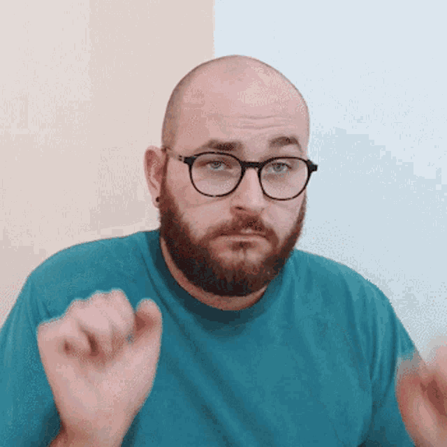 a bald man with a beard and glasses is making a funny face