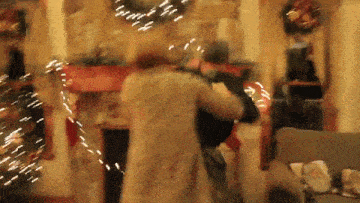 a blurry picture of a man and woman dancing in front of a fireplace .