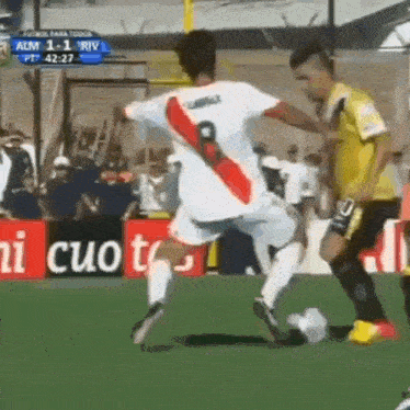 a soccer player with the number 8 on his jersey kicks the ball