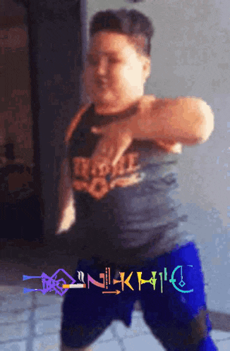 a young boy is dancing in front of a sign that says nilkhilc