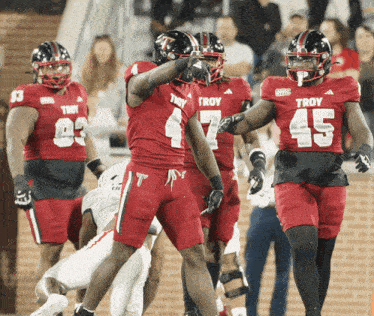 a group of troy football players are standing on the field