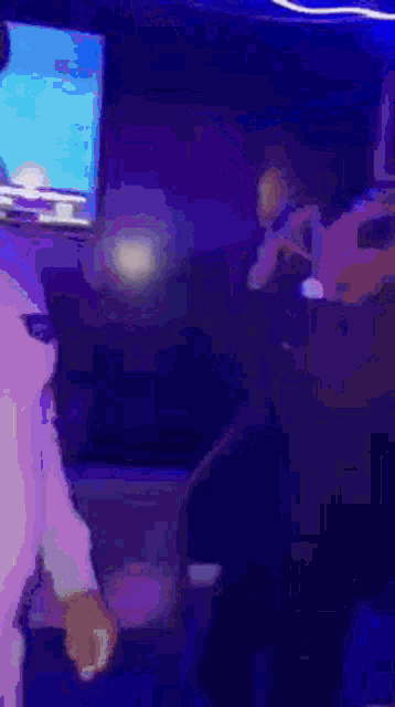 a man is singing into a microphone in front of a television