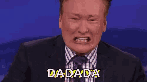 a man in a suit and tie is crying while making a funny face and saying dada .