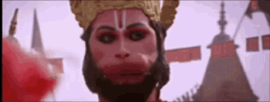 a close up of a monkey wearing a crown and a red nose .