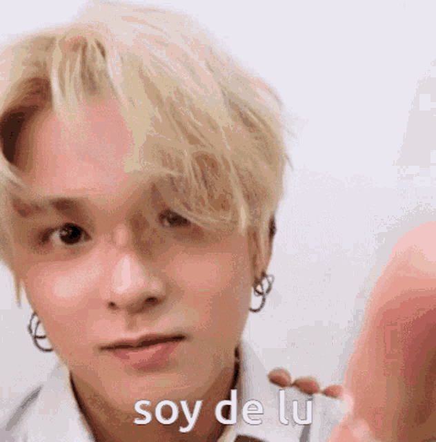 a close up of a young man 's face with the words soy de lu written on it .