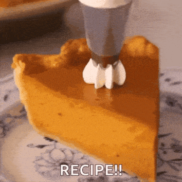 a slice of pumpkin pie with whipped cream being piped on it