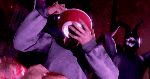 a person covering their face with a red bowl with the letter c on it