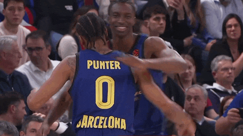 a basketball player wearing a number 0 jersey is hugging another player