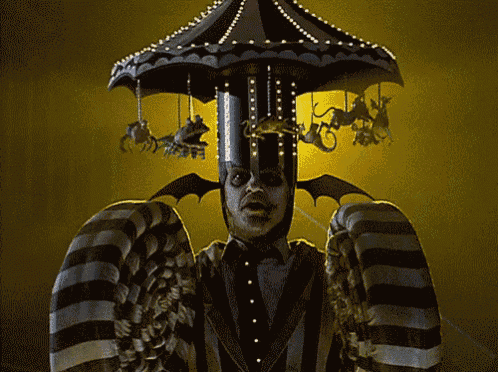 a man in a suit is standing in front of a carousel