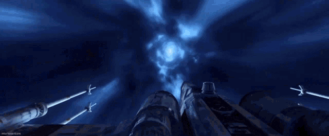 a star wars x-wing fighter jet is flying through a blue tunnel .