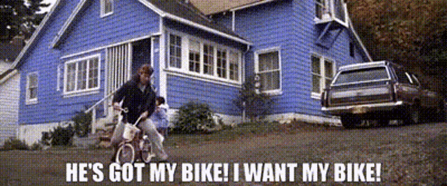a man riding a bike in front of a blue house that says he 's got my bike
