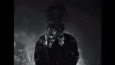 a black and white photo of a person in a dark room with smoke coming out of them