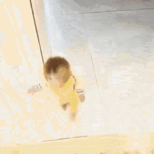 a baby is walking down a set of stairs in a room .