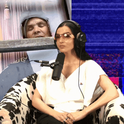 a woman wearing headphones sits in front of a microphone in a cow print chair