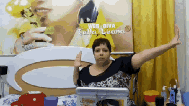 a woman is sitting in front of a poster that says web diva