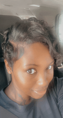 a close up of a woman 's face and hair in a car