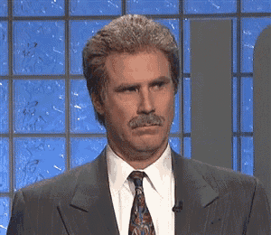a man with a mustache is wearing a suit and tie and making a face .