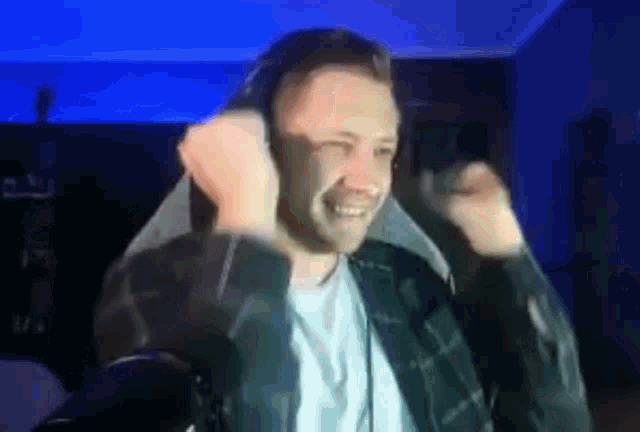 a man wearing headphones is sitting in a chair in front of a microphone .