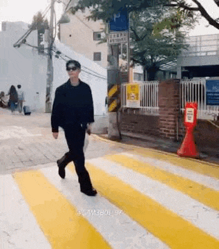 a man is walking across a zebra crossing on a city street .