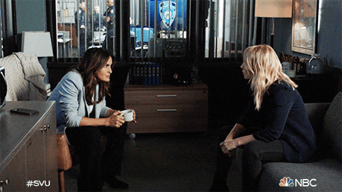 two women sit on a couch in a room with the nbc logo