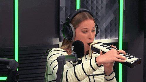 a woman wearing headphones is playing a keyboard in front of a microphone that says xerox
