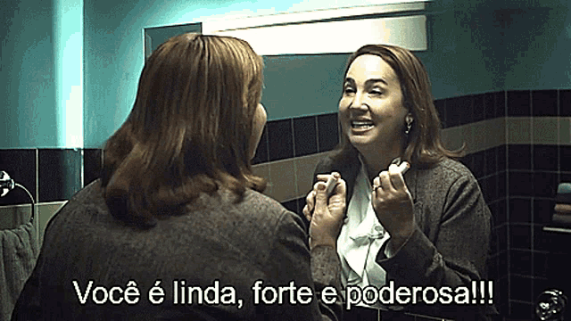 a woman is looking at herself in a mirror and says você é linda forte e poderosa !!!