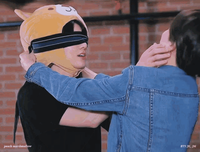 a man wearing a teddy bear hat is being held by a woman